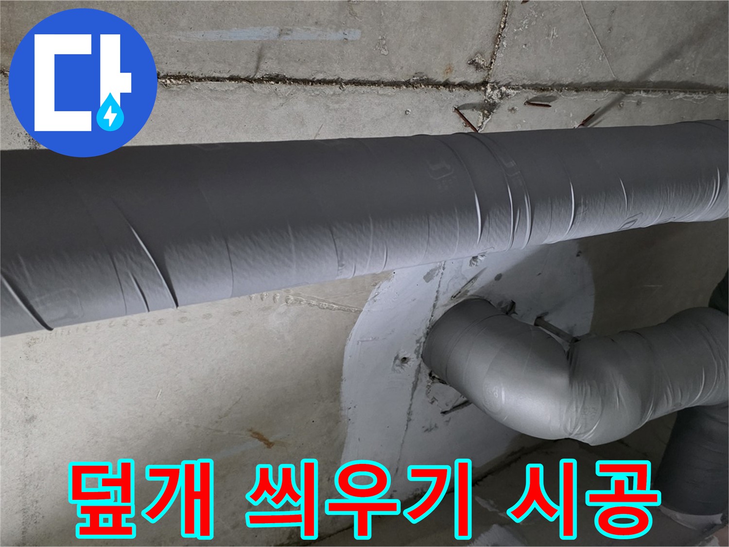 회색 단열재로 감싸진 굴곡진 형태의 천장 내부 배관입니다.