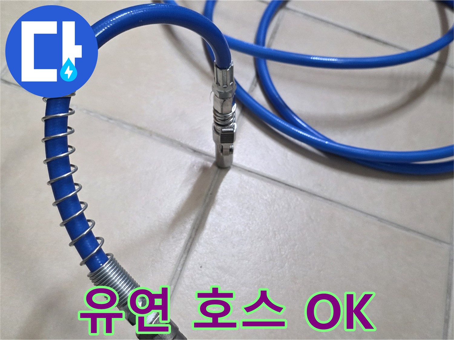 타일 바닥 위를 지나가는-파란색 배관 점검용 호스
