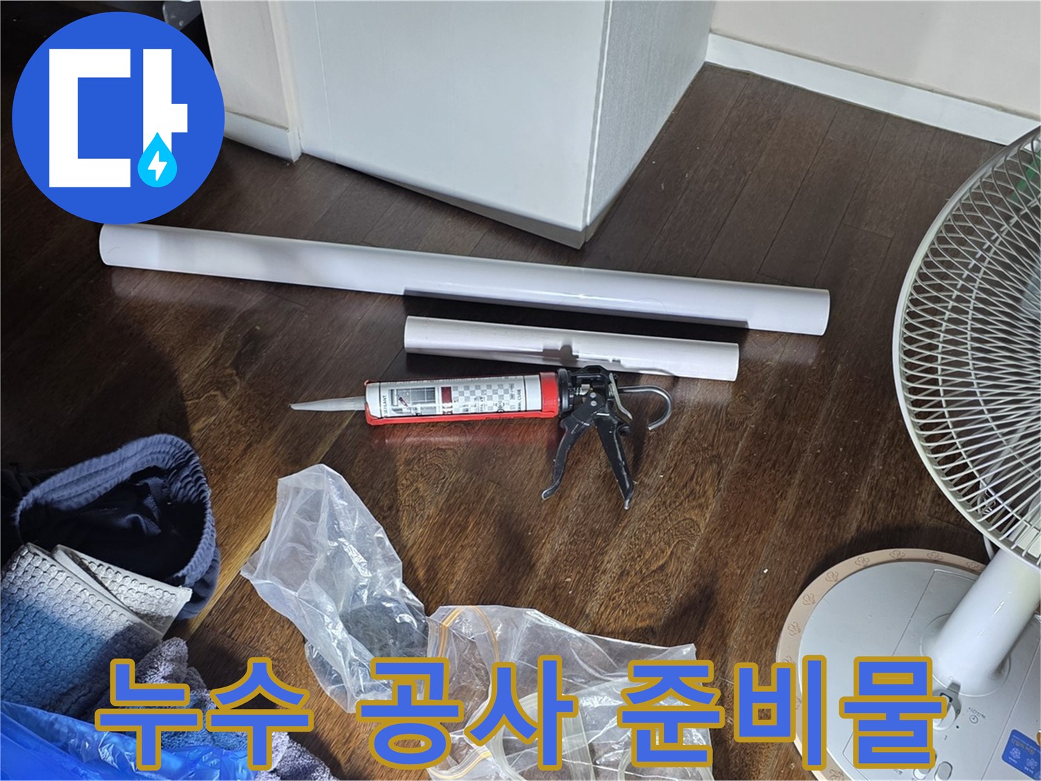 누수 공사를 위한 준비물 - 배관, 실리콘, 공구 등이 가지런히 놓여 있습니다.