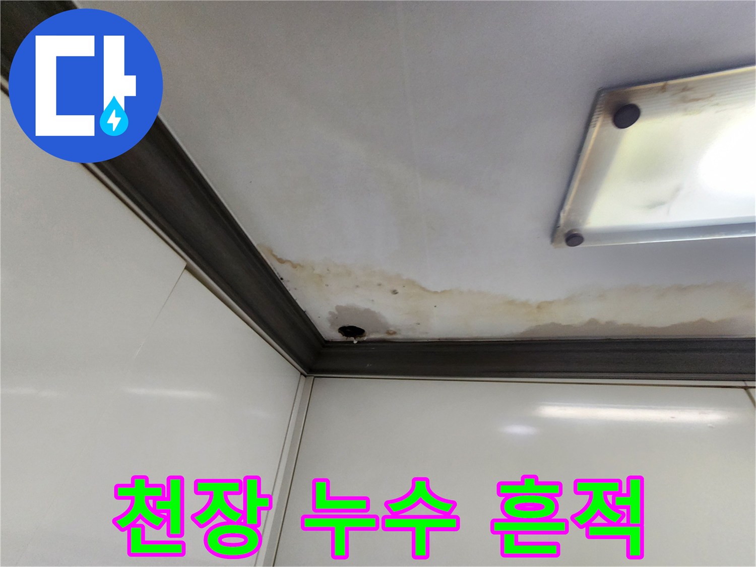 주방 천장 모서리 부근의 젖은 얼룩과 변색된 마감재