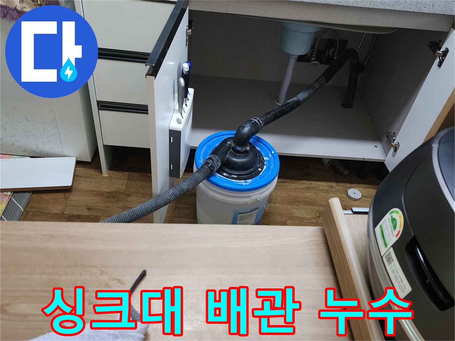 배관에서 떨어지는 물을 받기 위해 싱크대 밑에 놓인 양동이