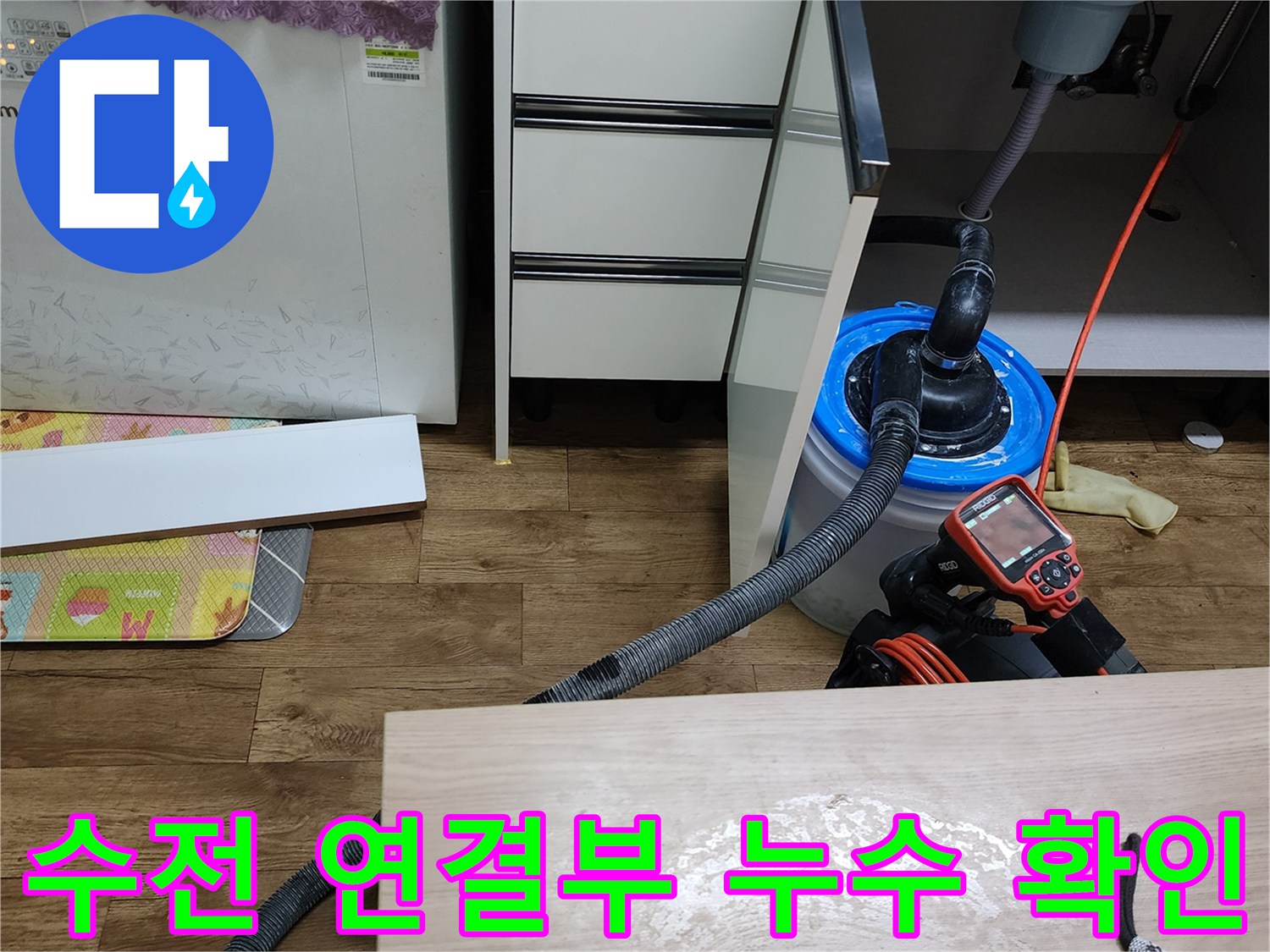 싱크대 아래 배관과 누수 탐지용 디지털 장비 모습