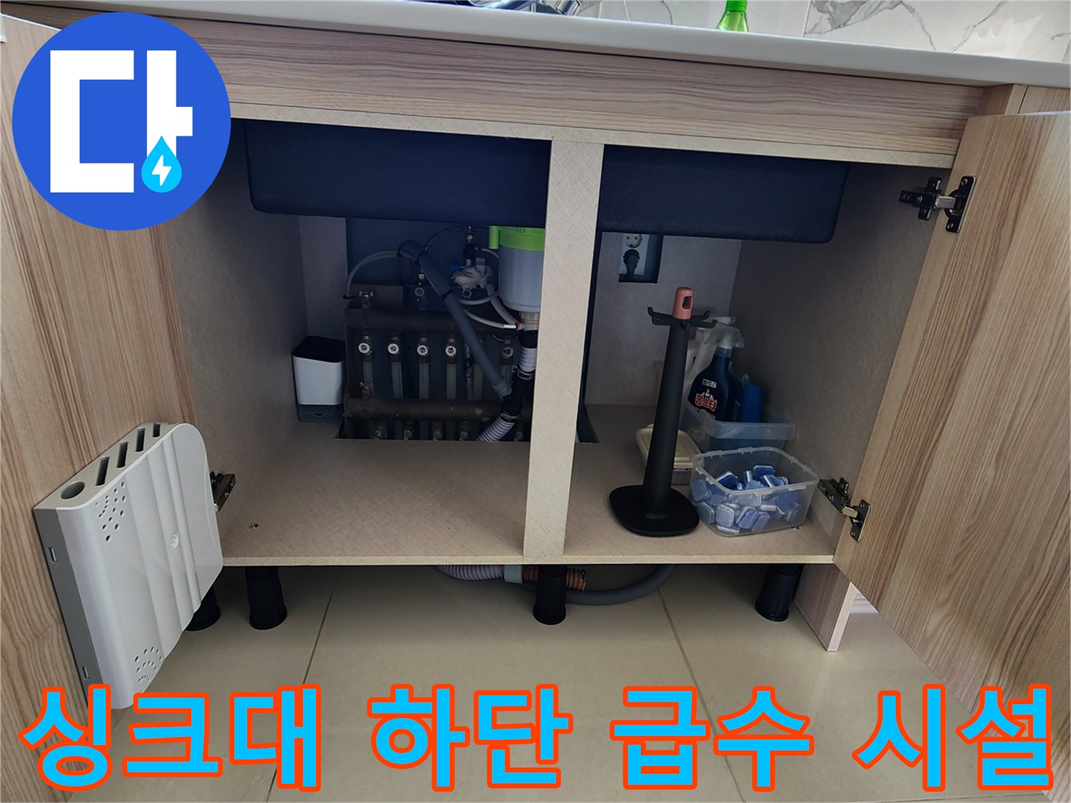 주방 싱크대 아래쪽의 밸브와 연결 호스 및 배수구 구조