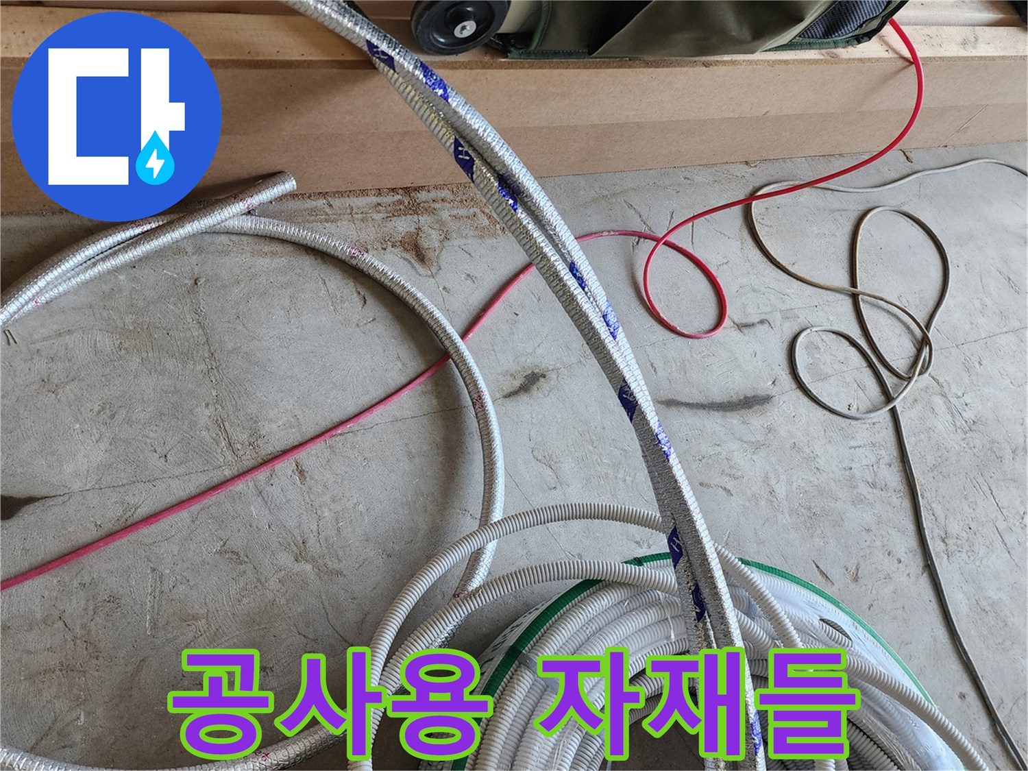 바닥에 놓인 흰색 배관 롤과 작업 전선