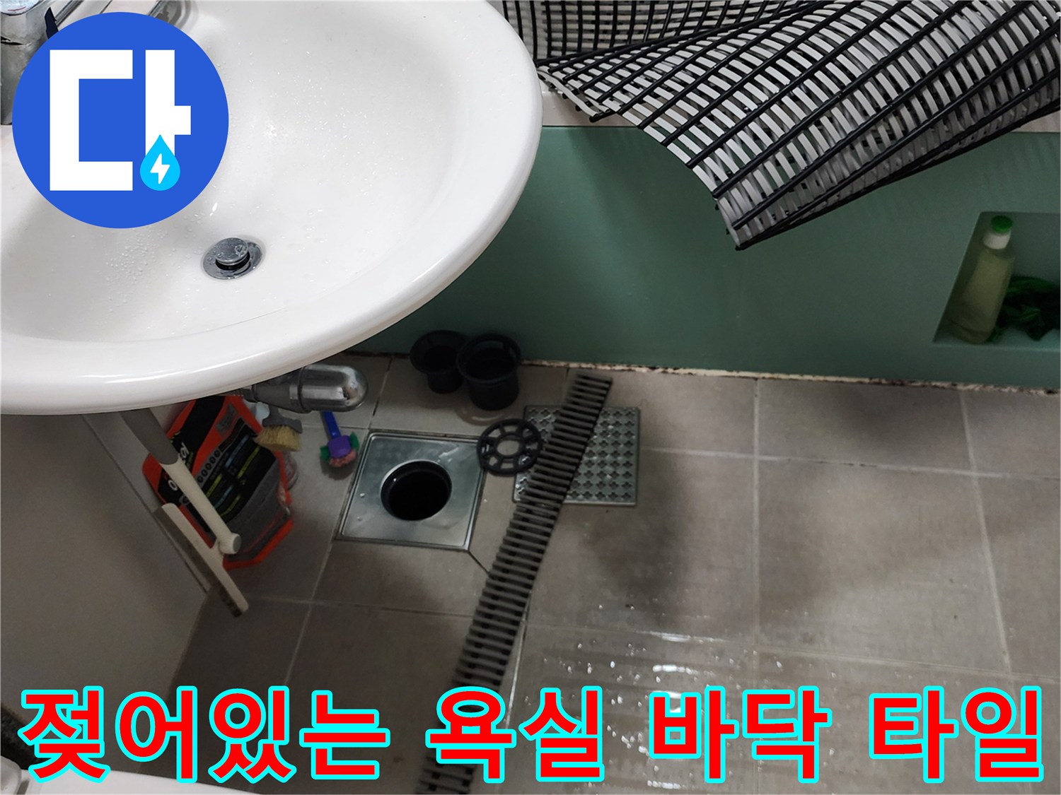 세면대 아래쪽 젖은 타일과 배수구 주변의 현장 상황