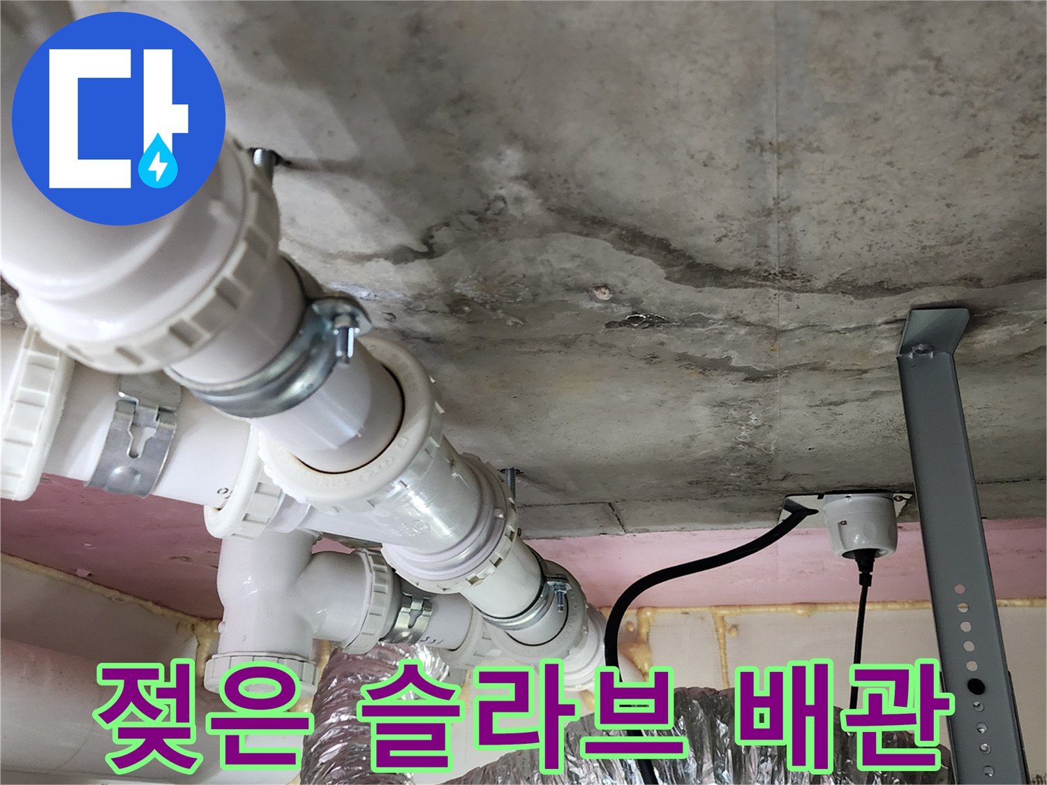 습기로 인해 어둡게 변한 천장 콘크리트와 PVC 배관 구조물