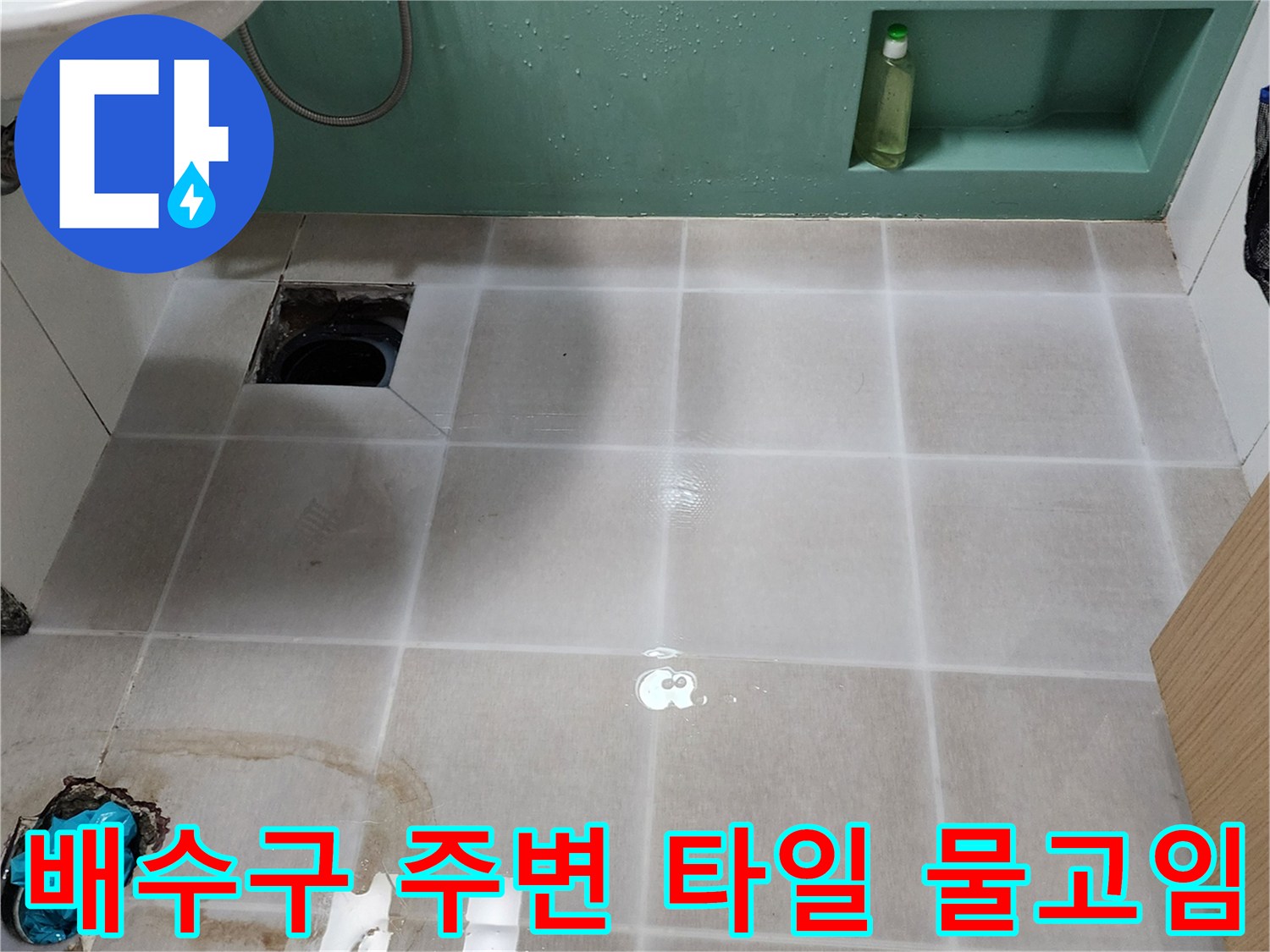하수구 입구 쪽으로 물이 고여 있는 욕실 바닥 사진