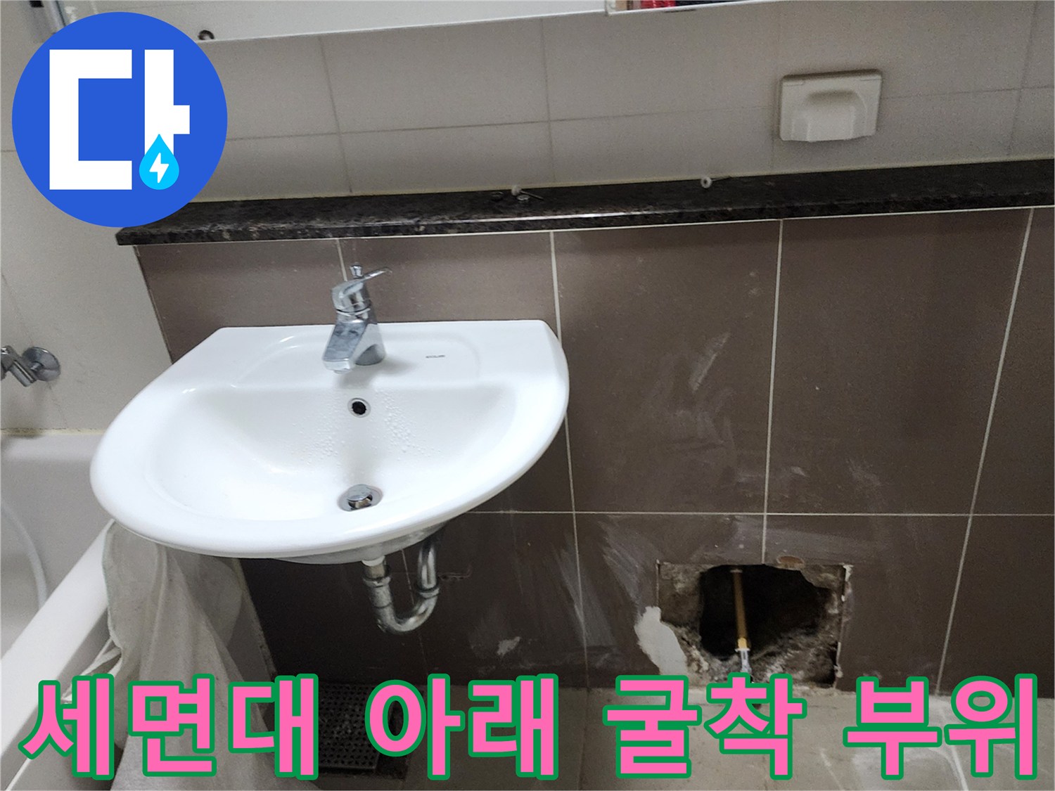 벽 타일을 제거하여 드러난 세면대 하단 수도 배관