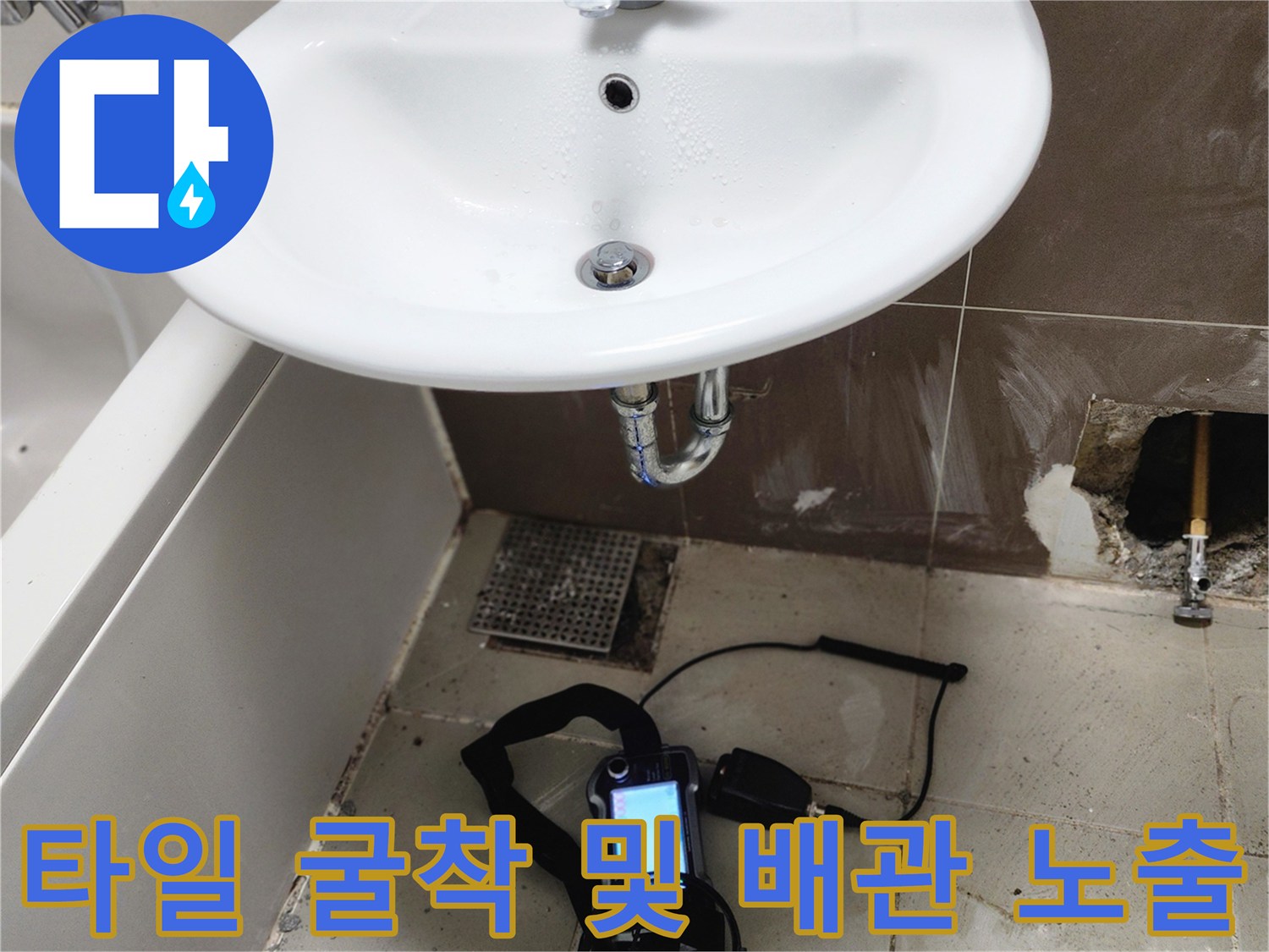 세면대 아래 벽면 배관과 누수 측정 장비의 모습