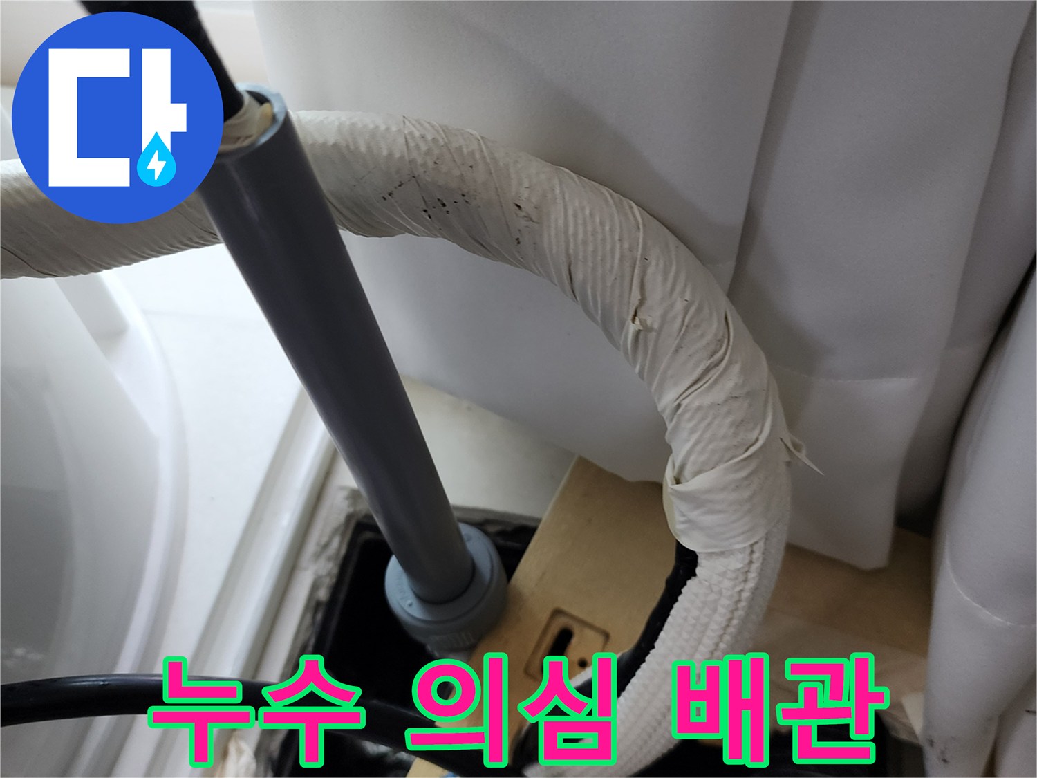 물기를 머금은 보온재와 회색 배관의 연결 부위입니다.