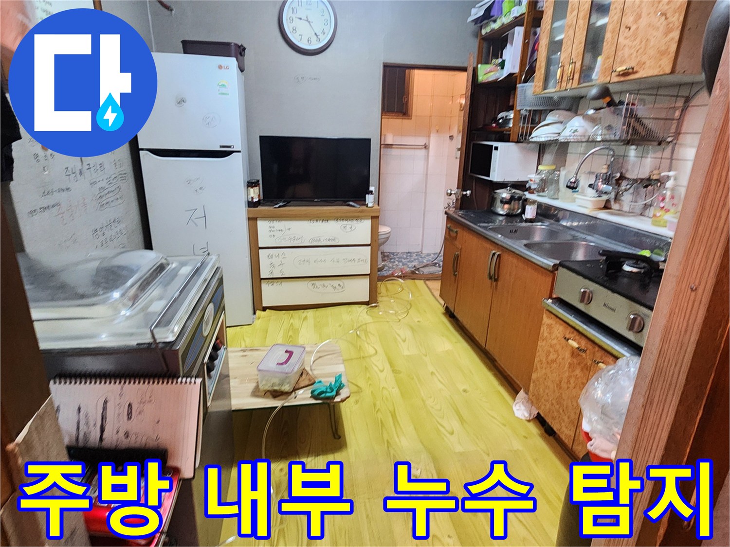 냉장고와 싱크대가 있는 주방 공간의 누수 점검 현장 사진