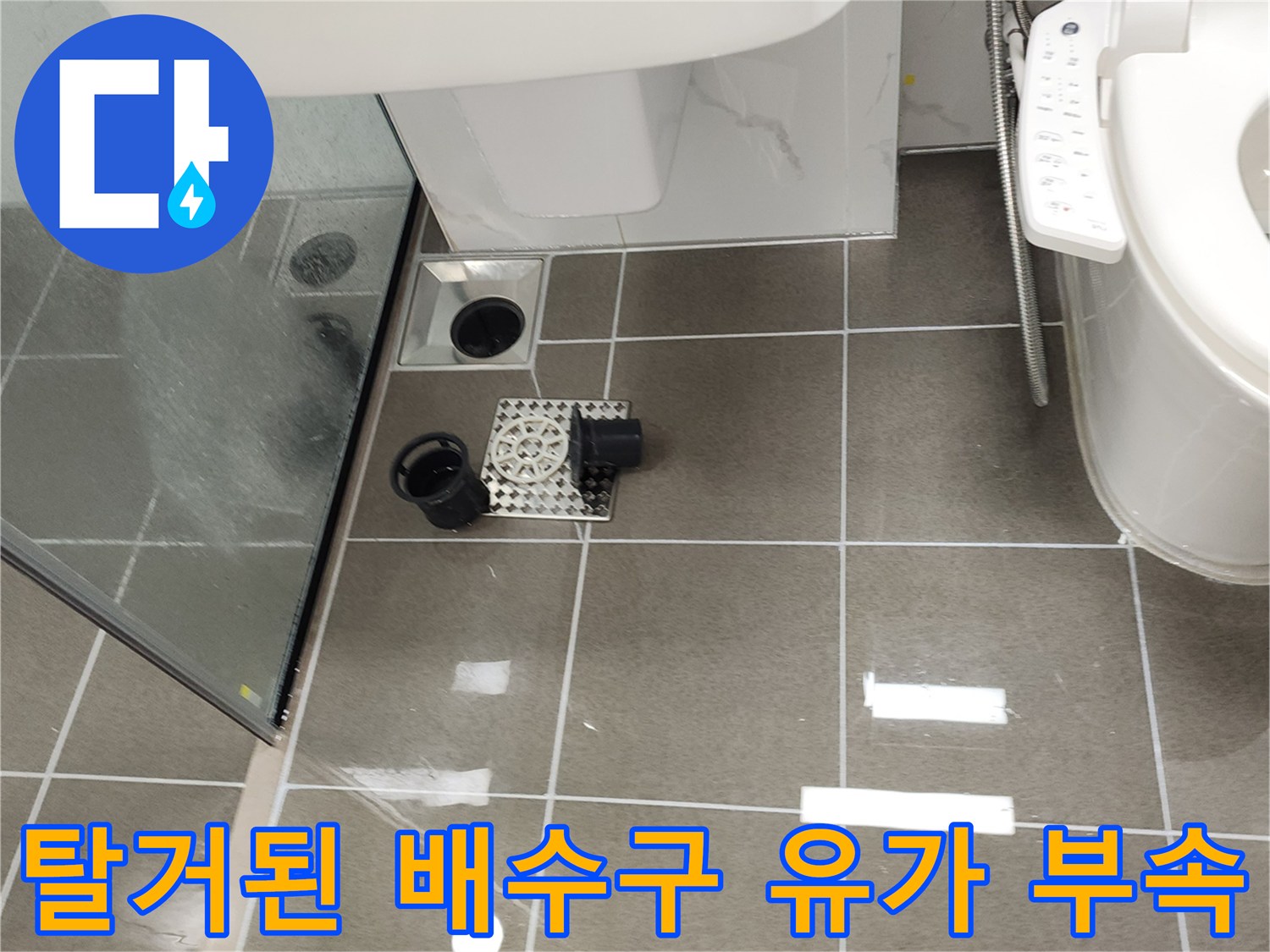 욕실 타일 바닥에 놓인 분리된 하수구 유가 덮개와 부품