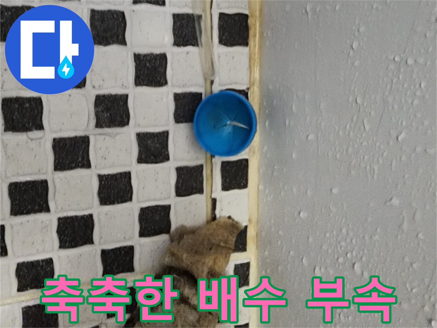 물기가 맺힌 파란색 배수 부품과 젖은 타일 바닥