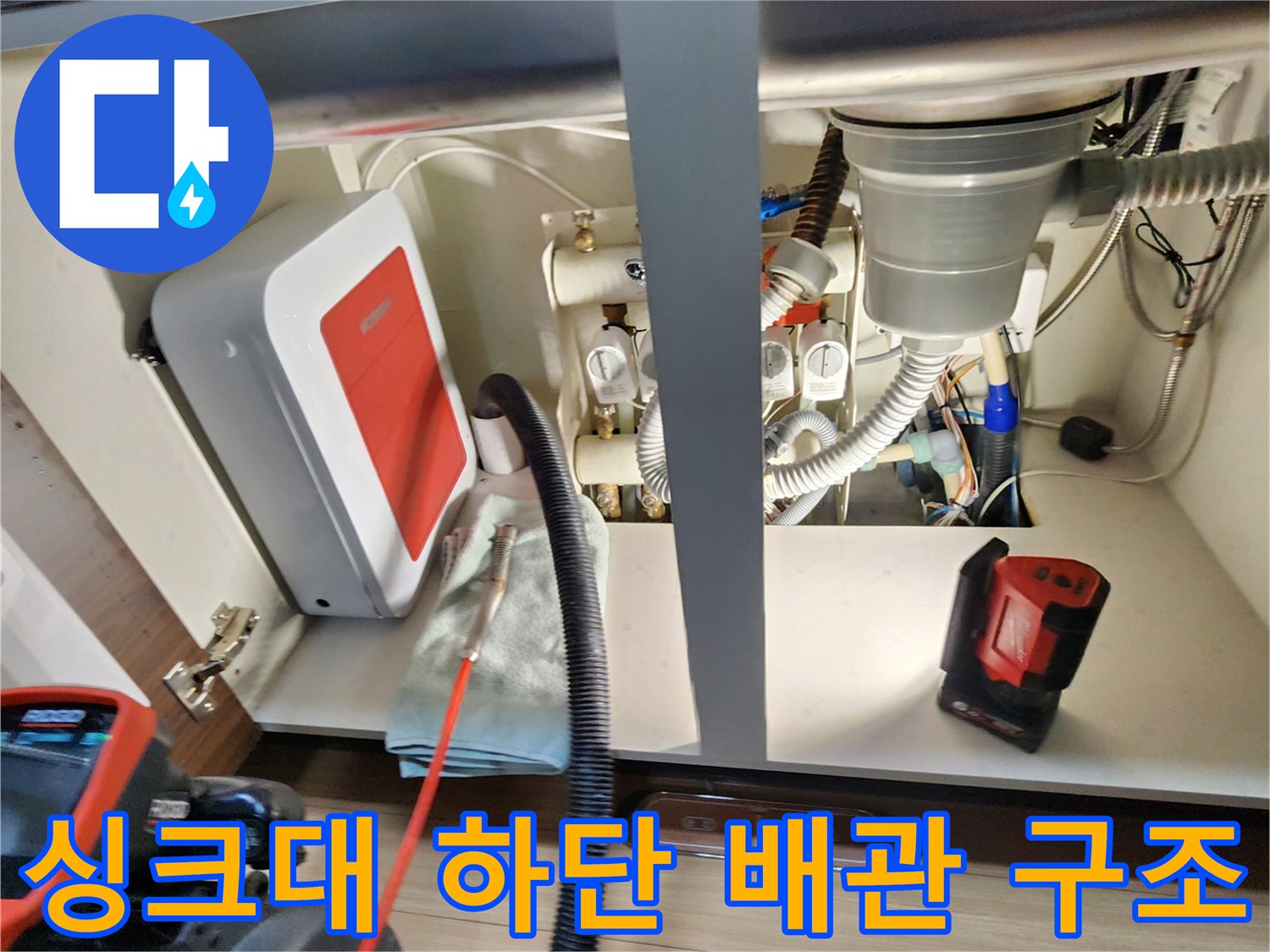 싱크대 밑에 위치한 급수 밸브와 배수 호스 연결 모습