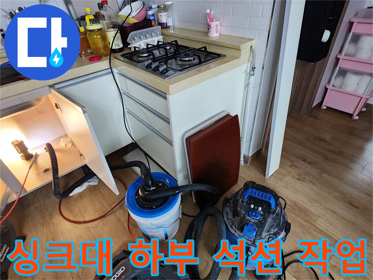 주방 싱크대 밑에서 진행하는 배관 이물질 제거 석션 장비 모습