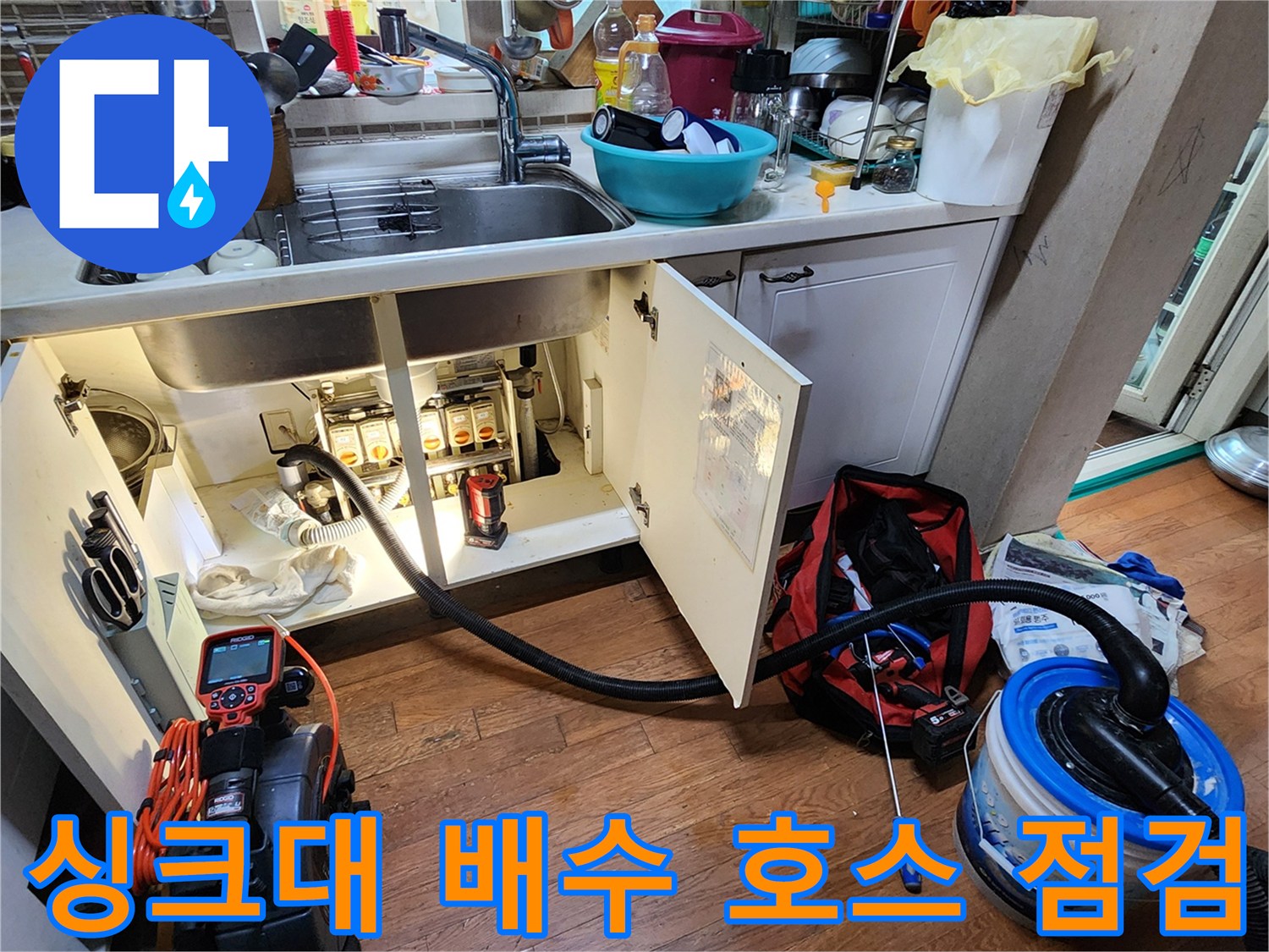 싱크대 아래쪽 밸브와 연결된 배수 관로를 정밀하게 살피는 모습