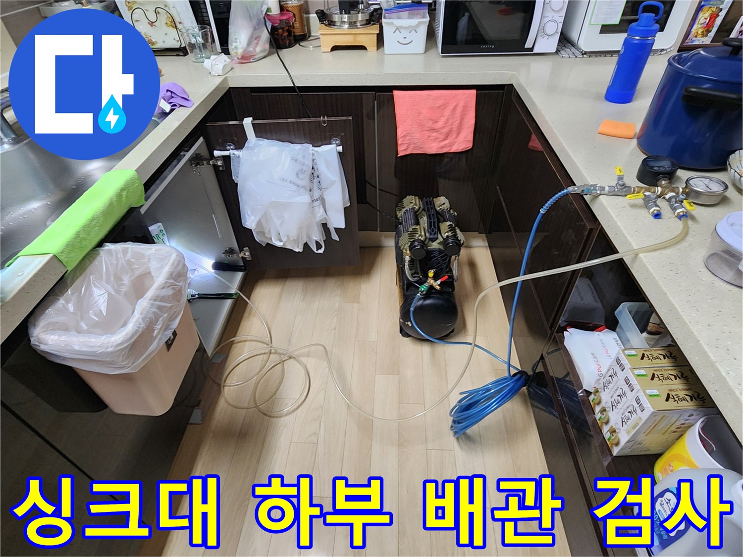 싱크대 아래쪽 배관 연결 부위의 압력을 측정하는 전문 장비 세팅