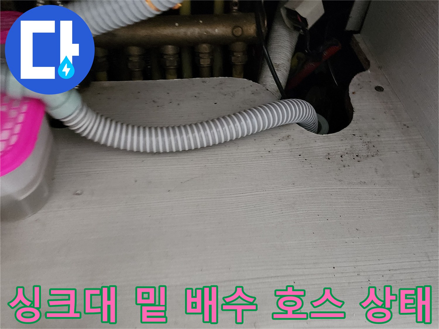 싱크대 하단에 설치된 회색 주름관과 주변 구조물