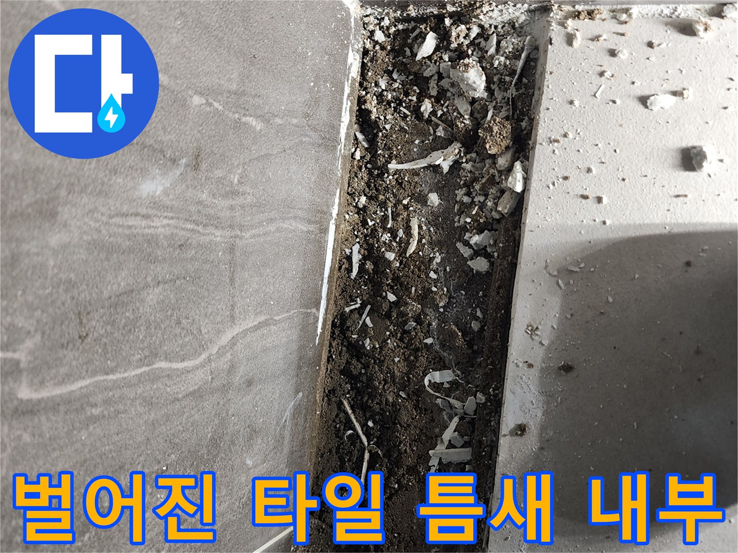 샤워실 바닥재와 하부 구조물 사이의 벌어진 공간을 나타내는 사진입니다.