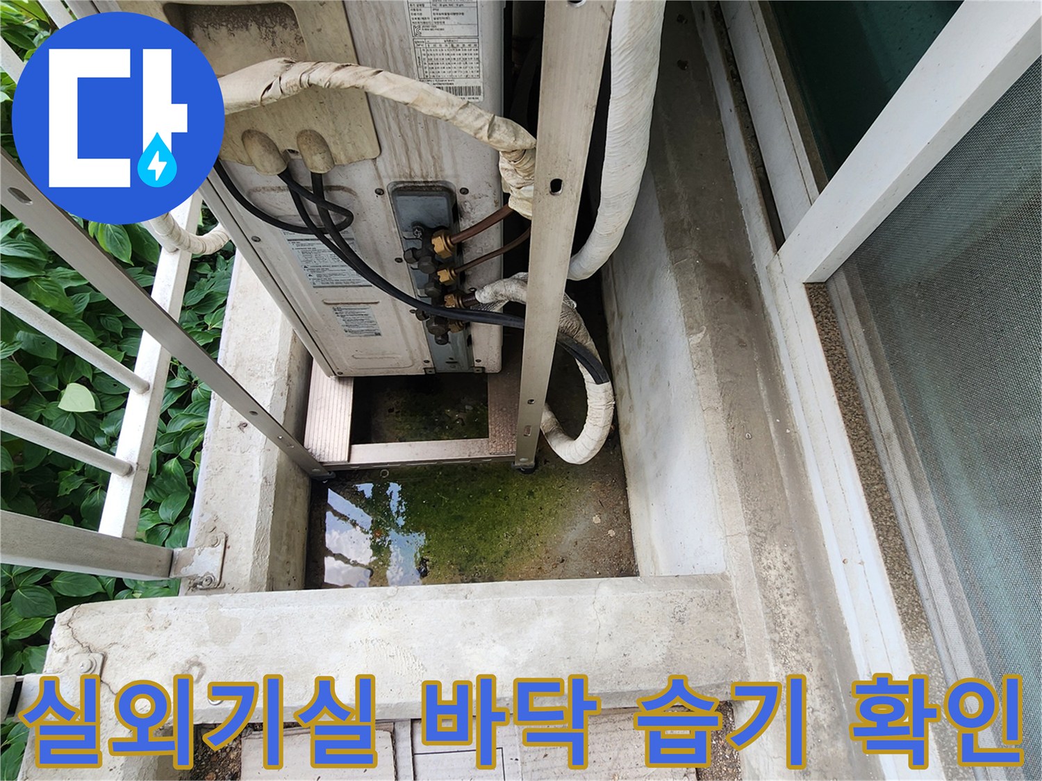 에어컨 실외기 배관 하단-바닥의 물고임과 습기를 보여주는 사진