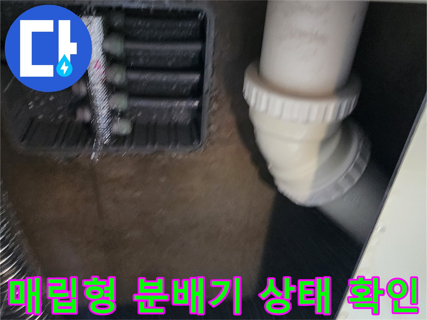 싱크대 하부 매립함 내의 배수관과 스테인리스 분배기 모습
