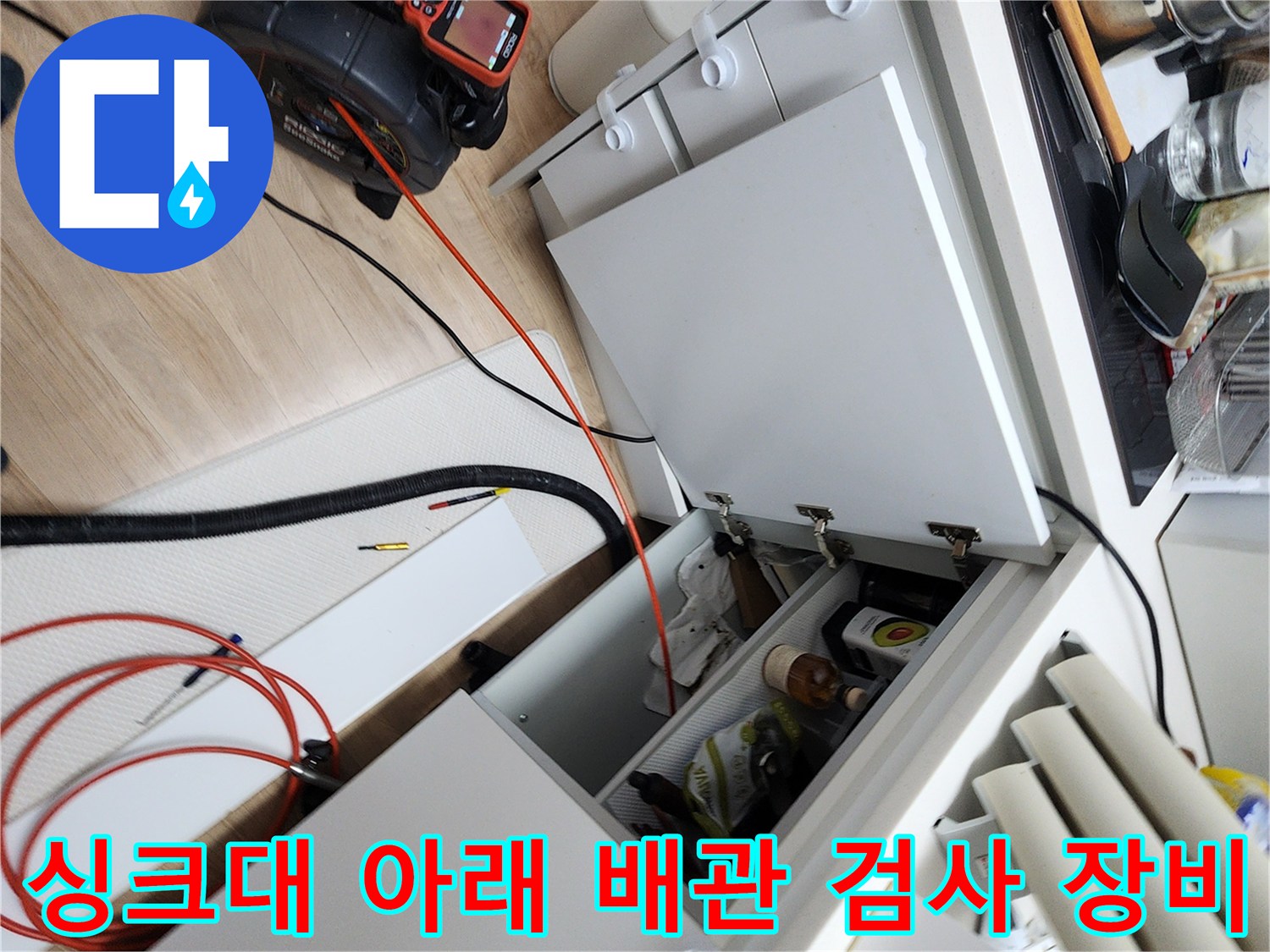 싱크대 하부 수납장 앞 바닥에 놓인 배관 진단용 전문 도구들
