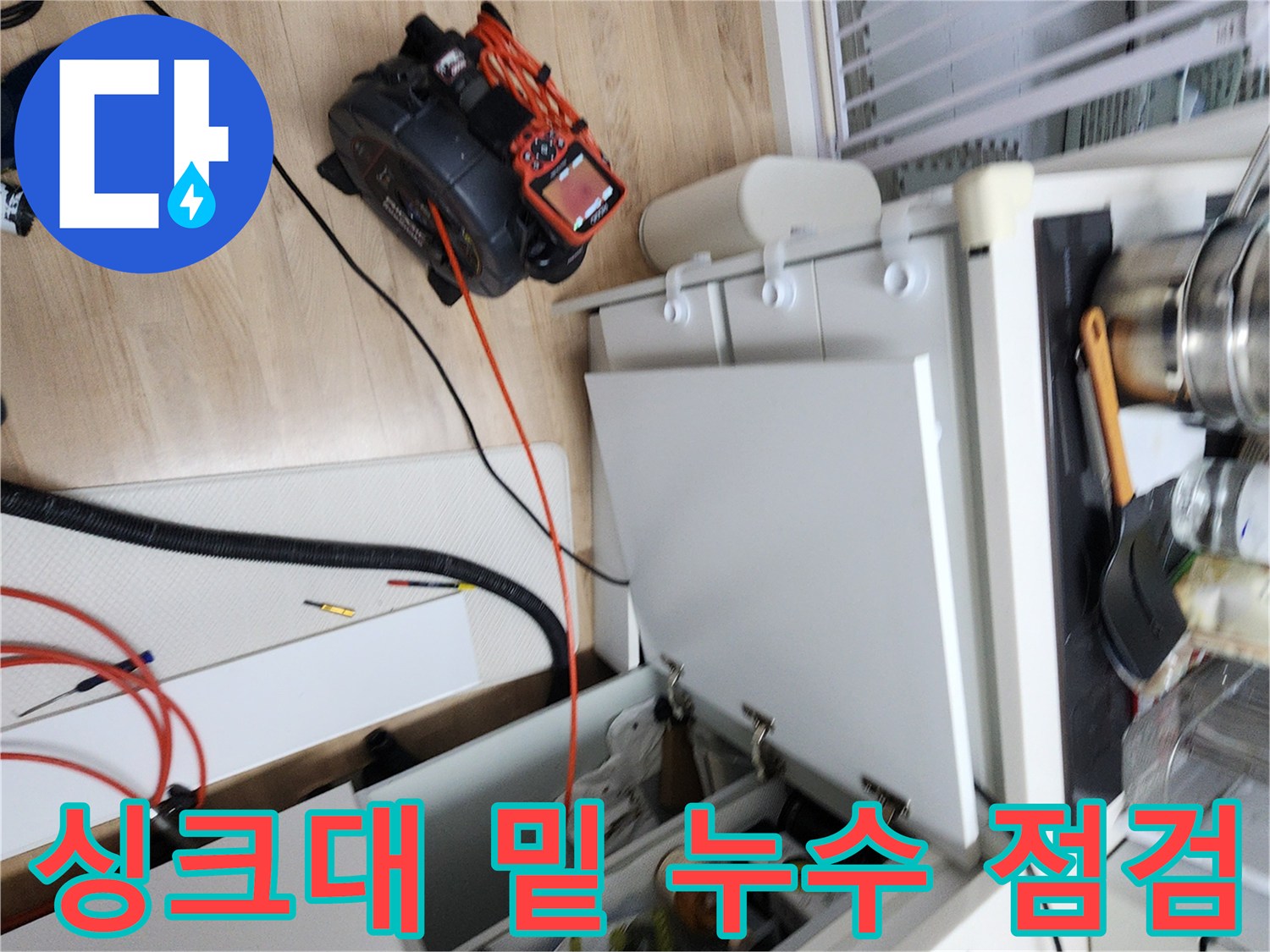 싱크대 하부장 내부의 배관과 작업용 장비 배치 상태