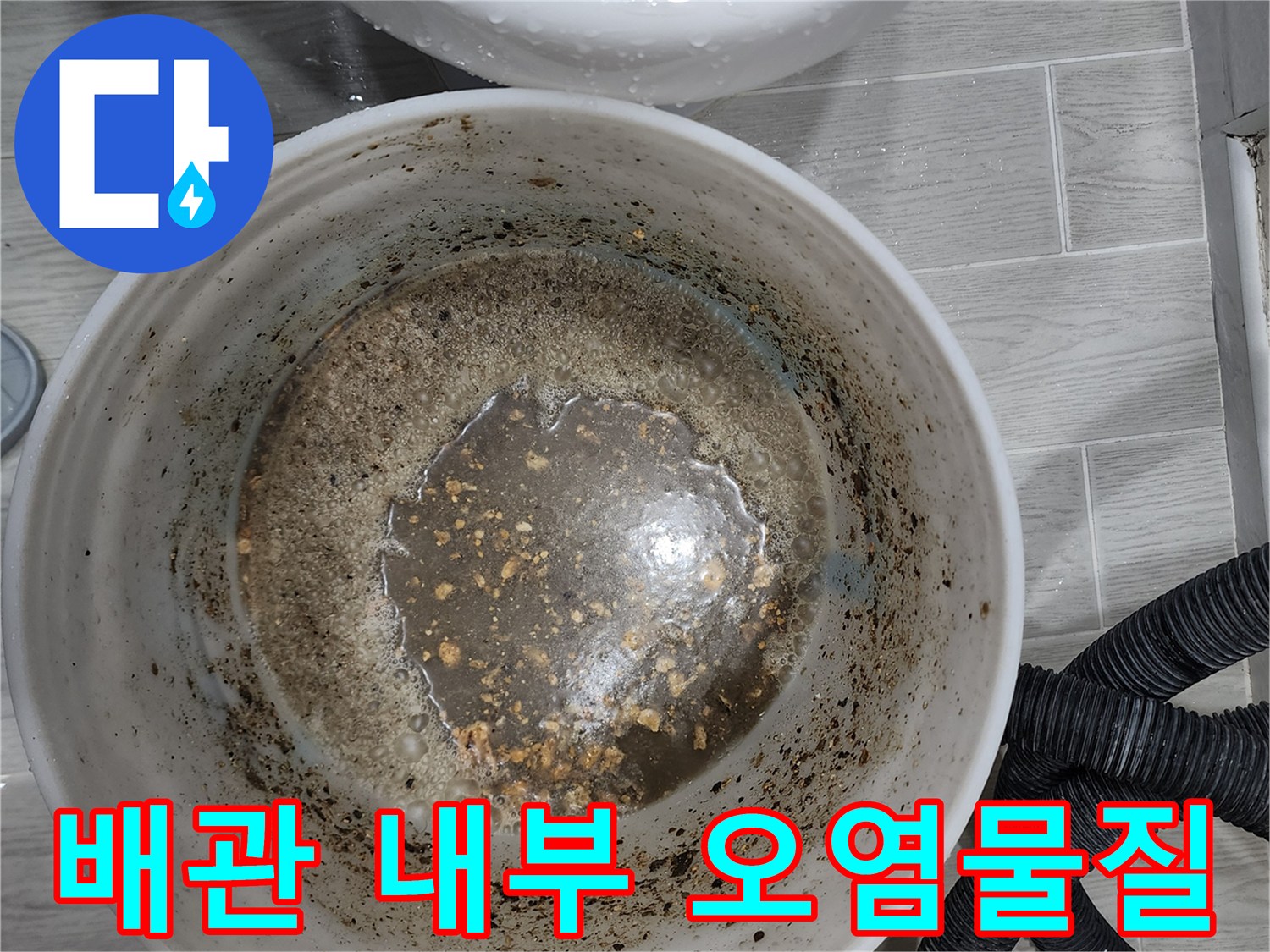 양동이에 담긴 배관 세척 후의 탁한 물과 슬러지