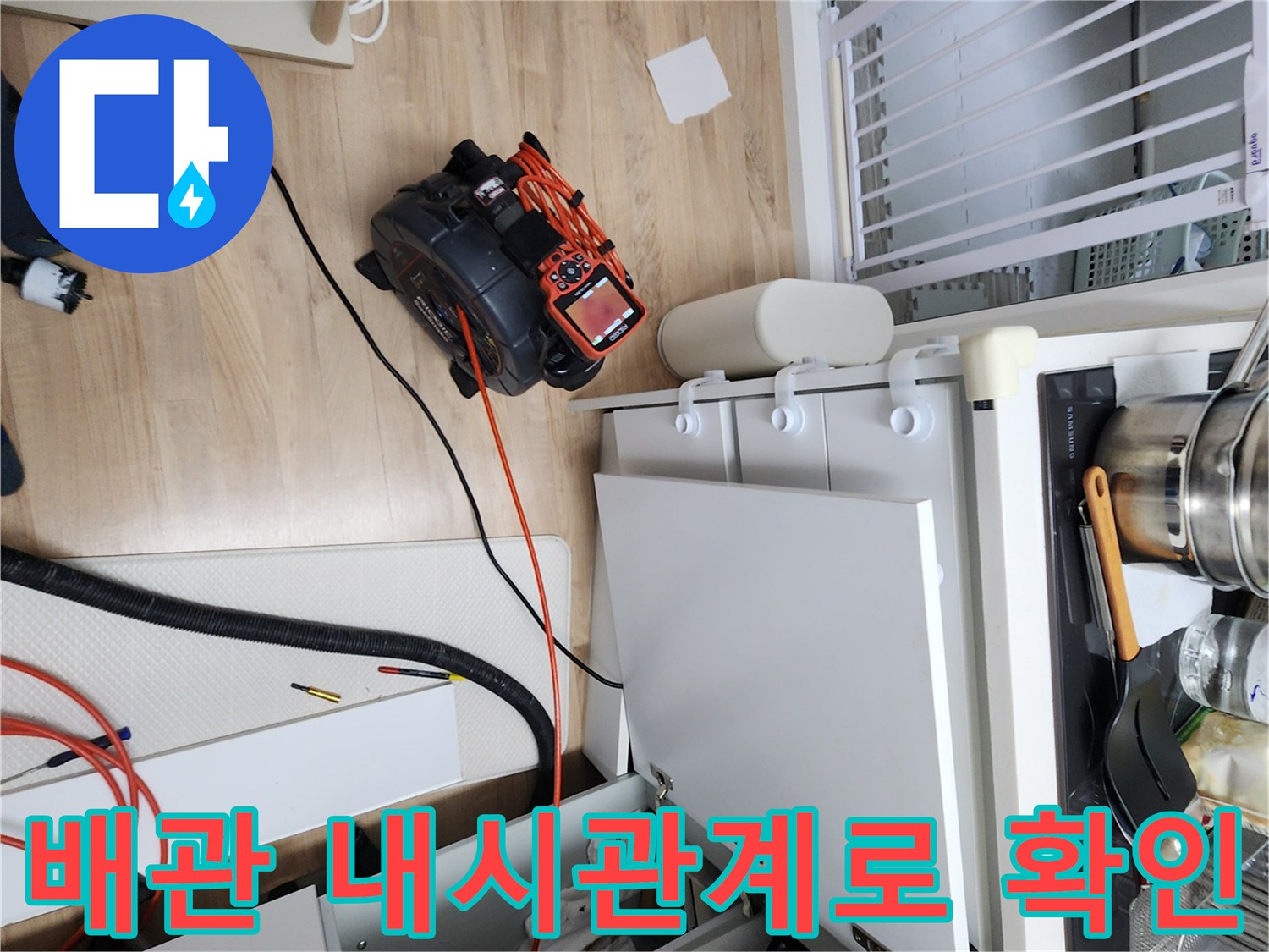 작업 중인 싱크대 아래쪽의 배관 진단용 모니터와 케이블 선