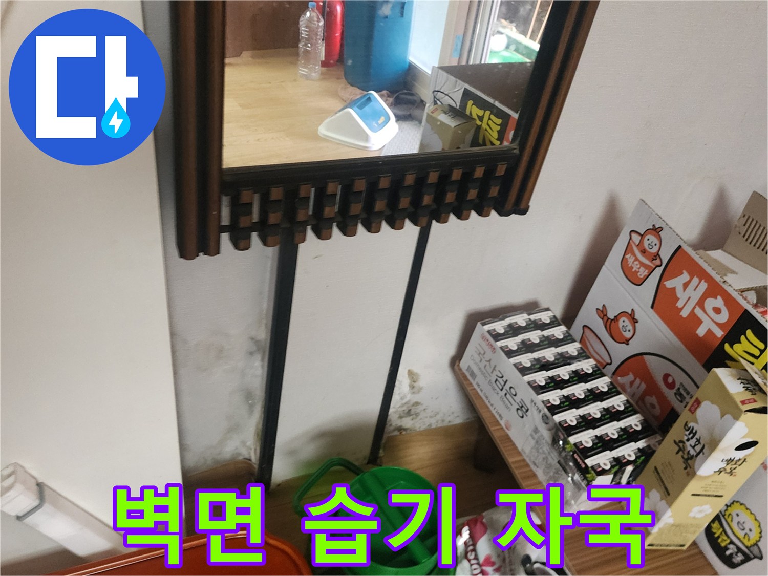 누수로 인해 물기가 스며들어 변색된 벽지 하단부