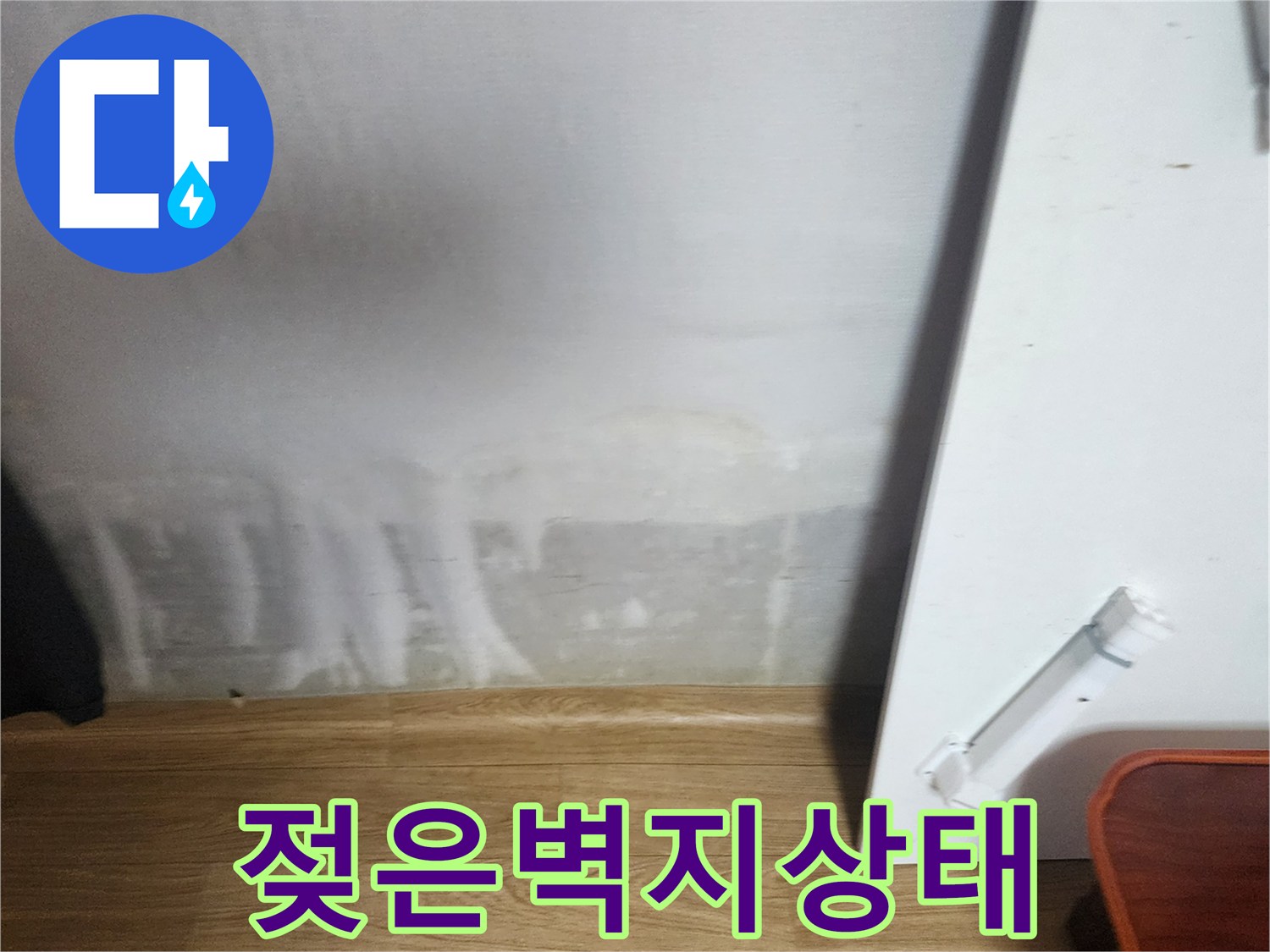 아파트 내부 벽면 아래쪽의 젖은 벽지 및 얼룩진 부위