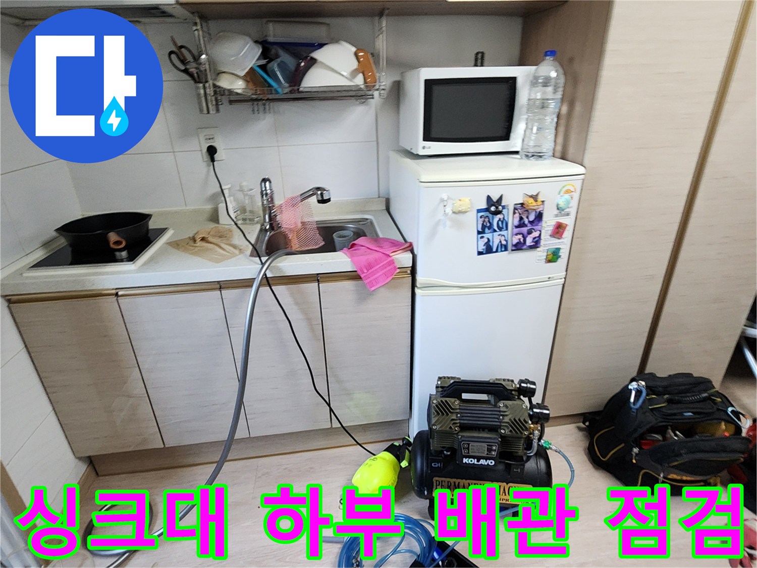 주방 싱크대 아래 배치된 누수 탐지용 공압 장비와 호스들