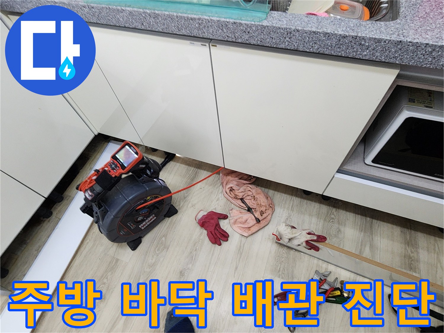 싱크대 아래 작업 공간에 놓여 있는 압력 측정 장비와 공구들