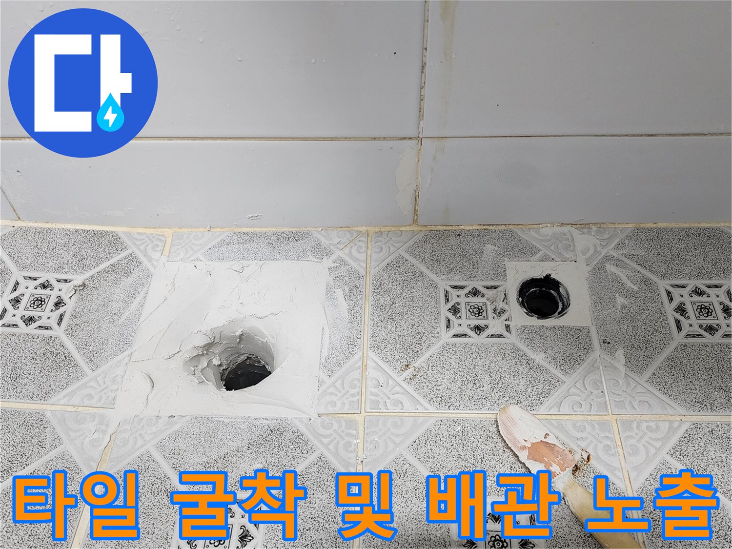 욕실 바닥 타일을 제거하여 드러난 배수구 파이프와 주변 마감재
