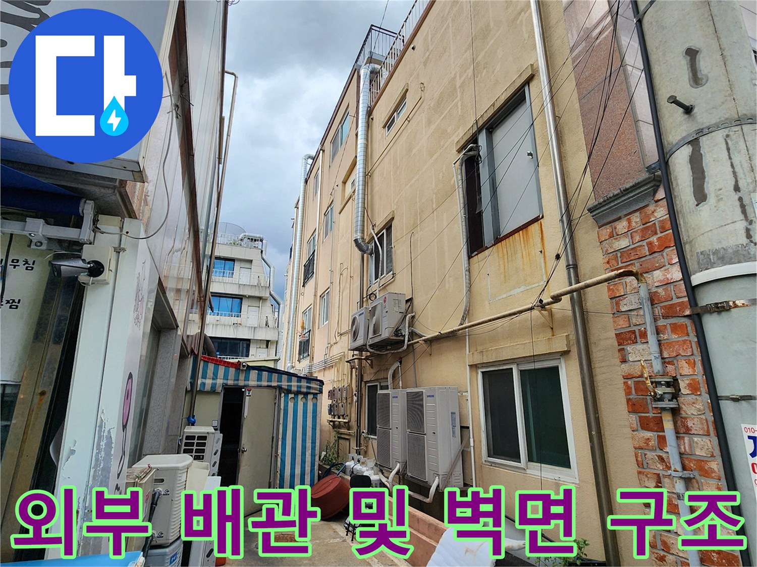 건물 외부의 배관 라인과 외벽 마감재 상태