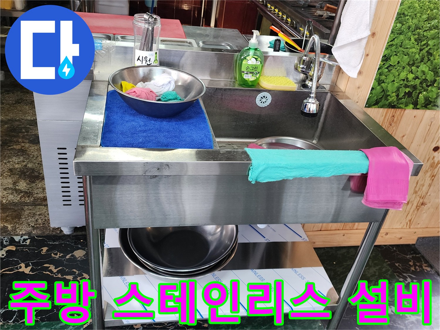 식당 주방의 스테인리스 싱크대와 주변 조리 도구