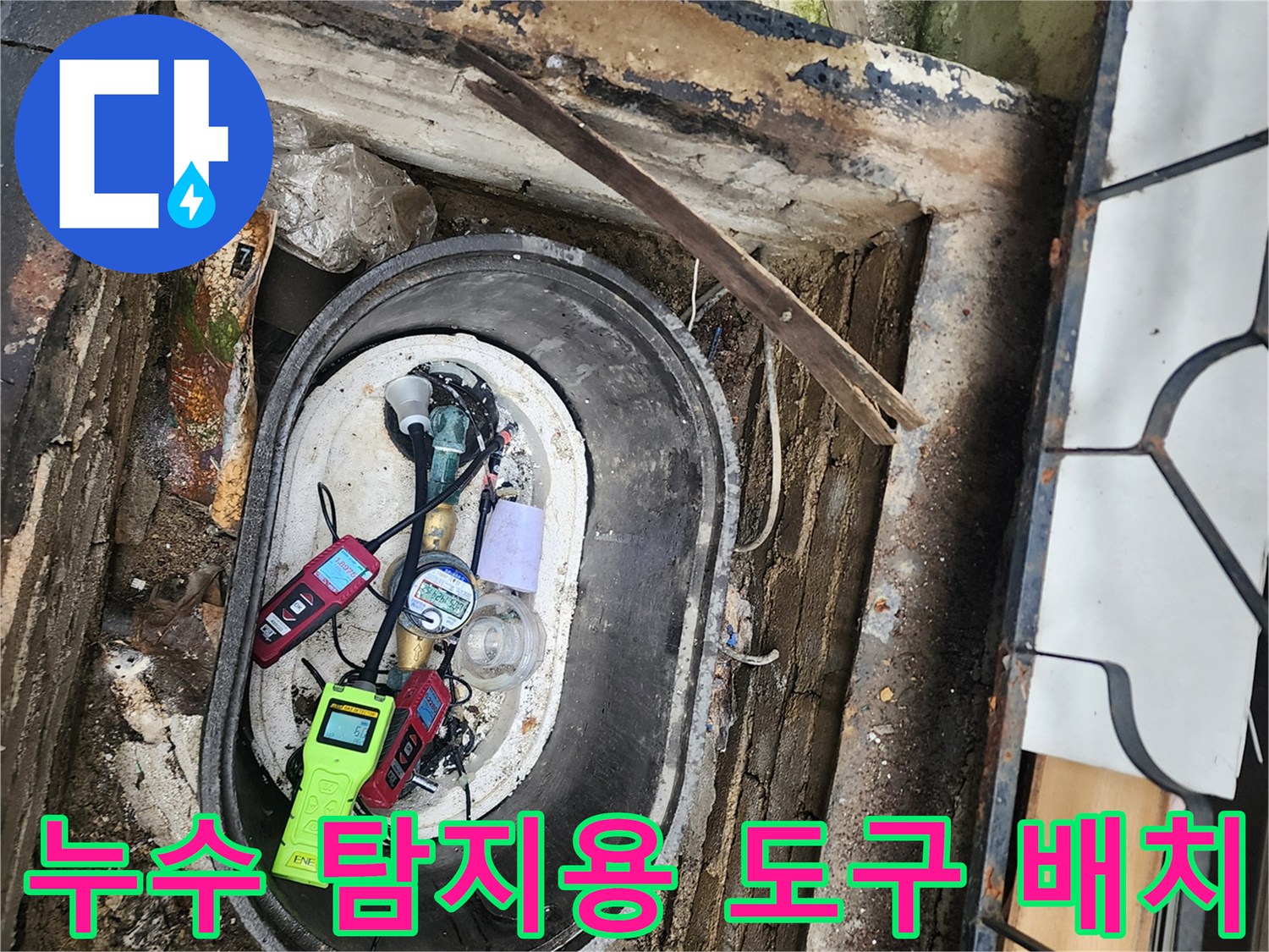 축축한 계량기 함 바닥에 놓인 여러 가지 누수 탐지 장비
