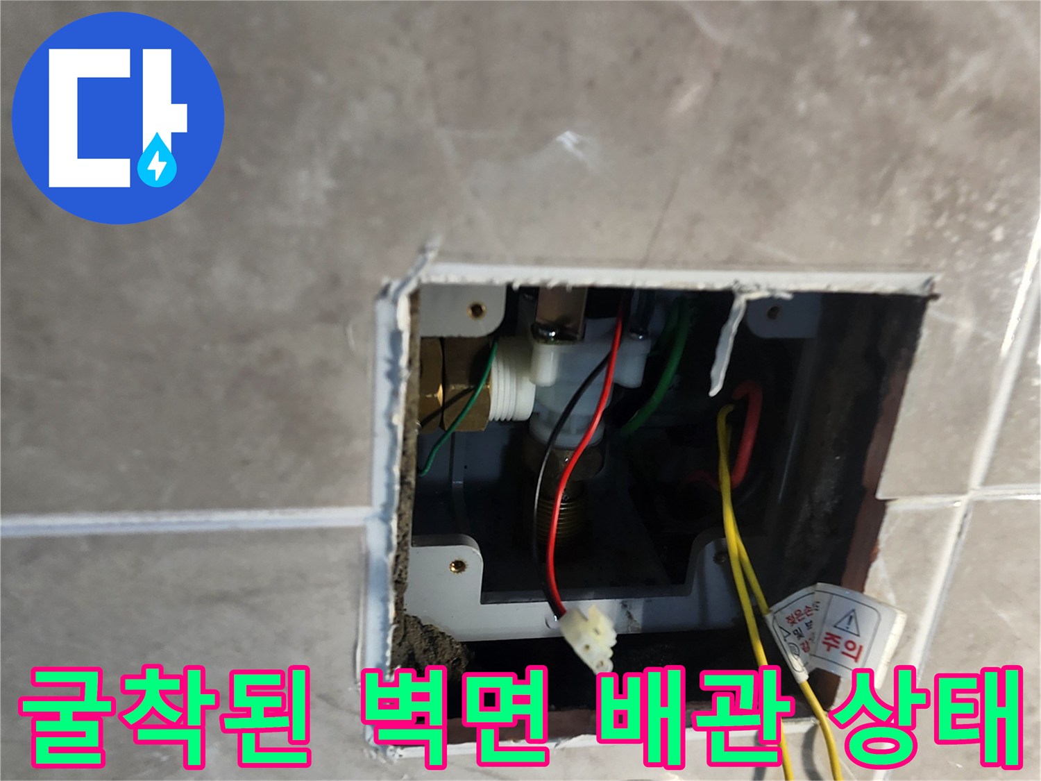타일-안쪽의-소변기-급수-배관과-노출된-전선-모습