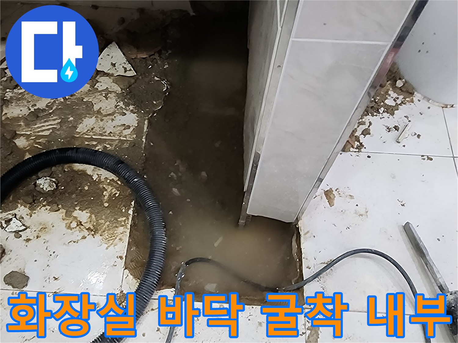 타일 제거 부위 아래에 고여 있는 탁한 물과 잔해물