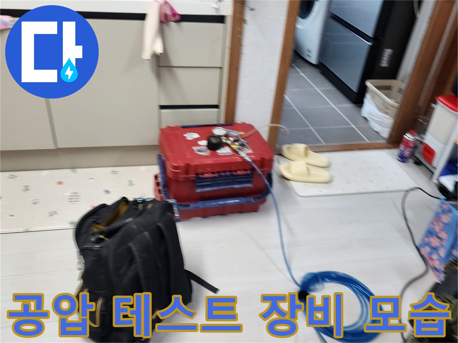 바닥에 놓인 누수 탐지용 압력 측정기와 파란색 에어 호스