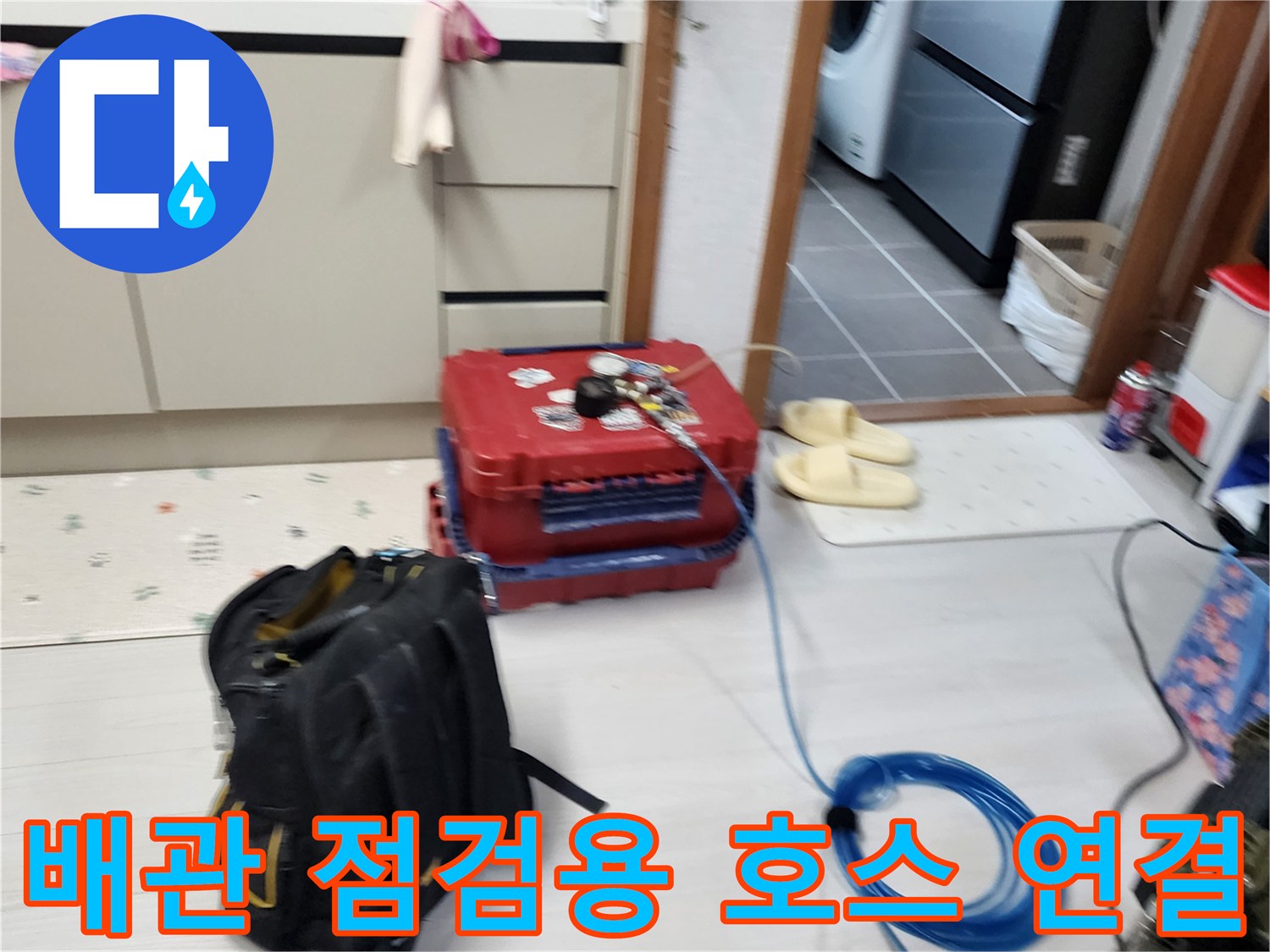 바닥에 펼쳐진 파란색 에어 호스와 압력 측정 장비