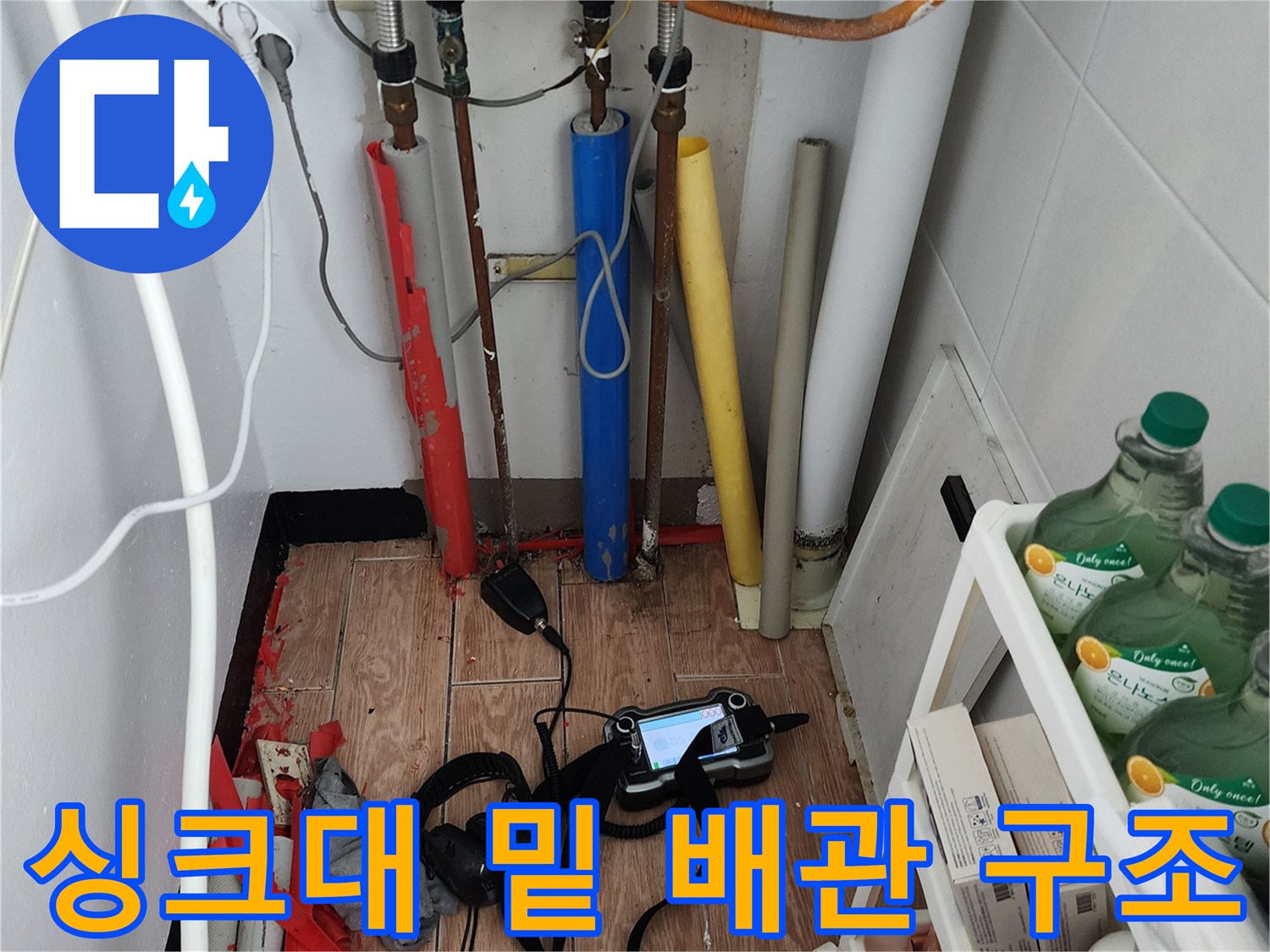 복잡하게 연결된 주방 하부 배관과 점검용 장비들의 모습
