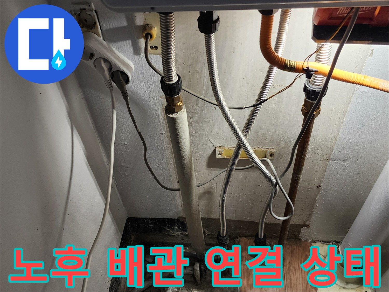 싱크대 하단에 위치한 노후된 주름관과 PVC 배관의 모습