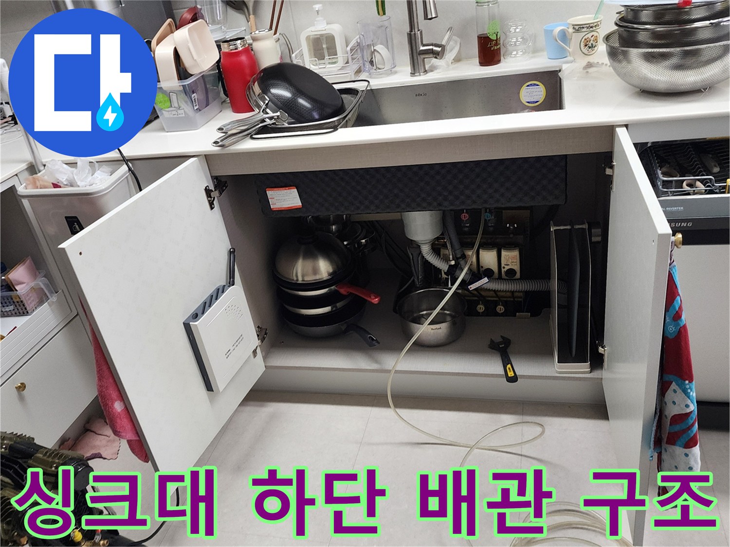 주방 싱크대 하부의 배수 파이프 및 연결 부위 상세 모습