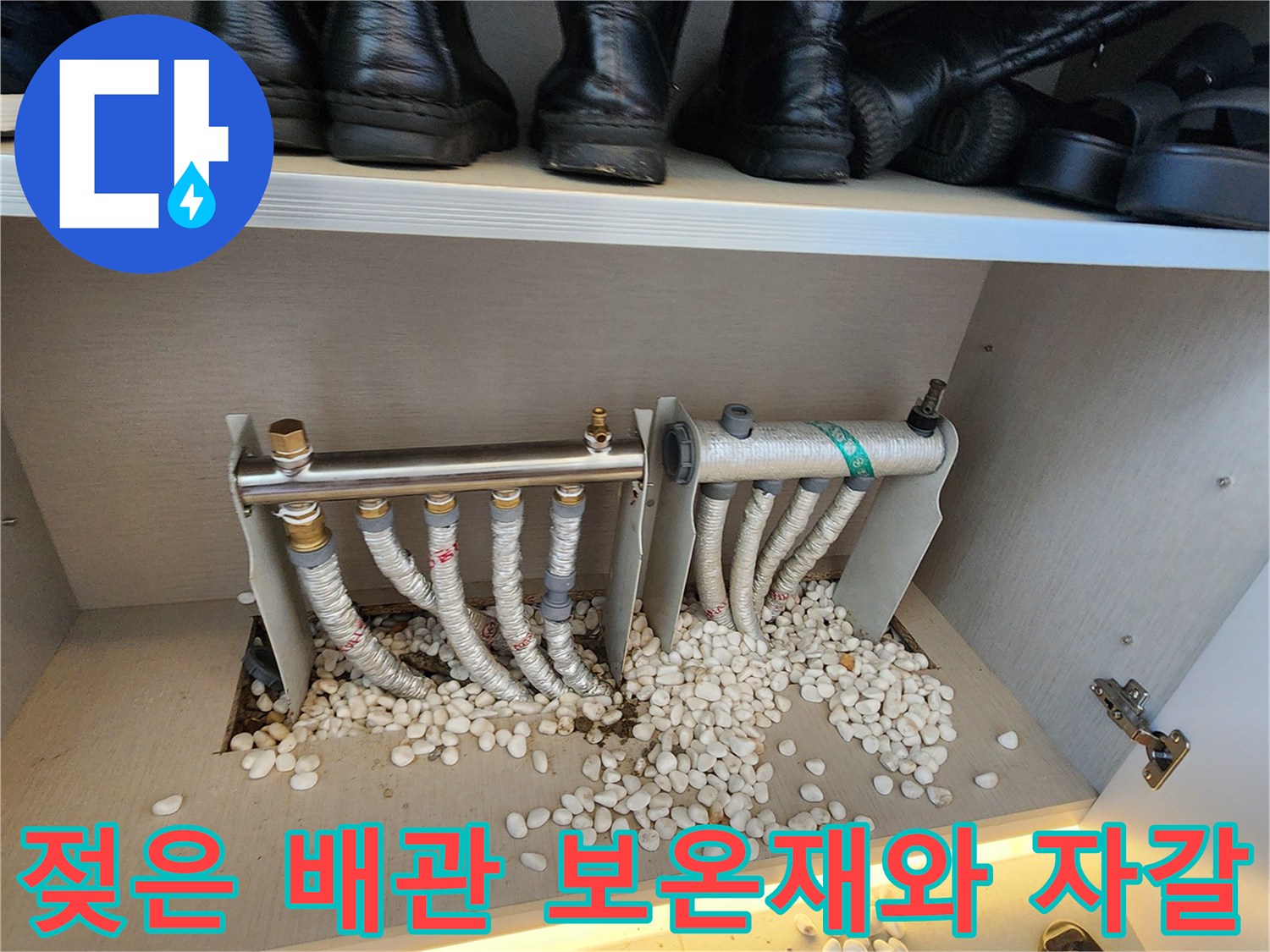 보온재로 감싸진 난방 배관과 젖어 있는 하단 자갈층 사진입니다.