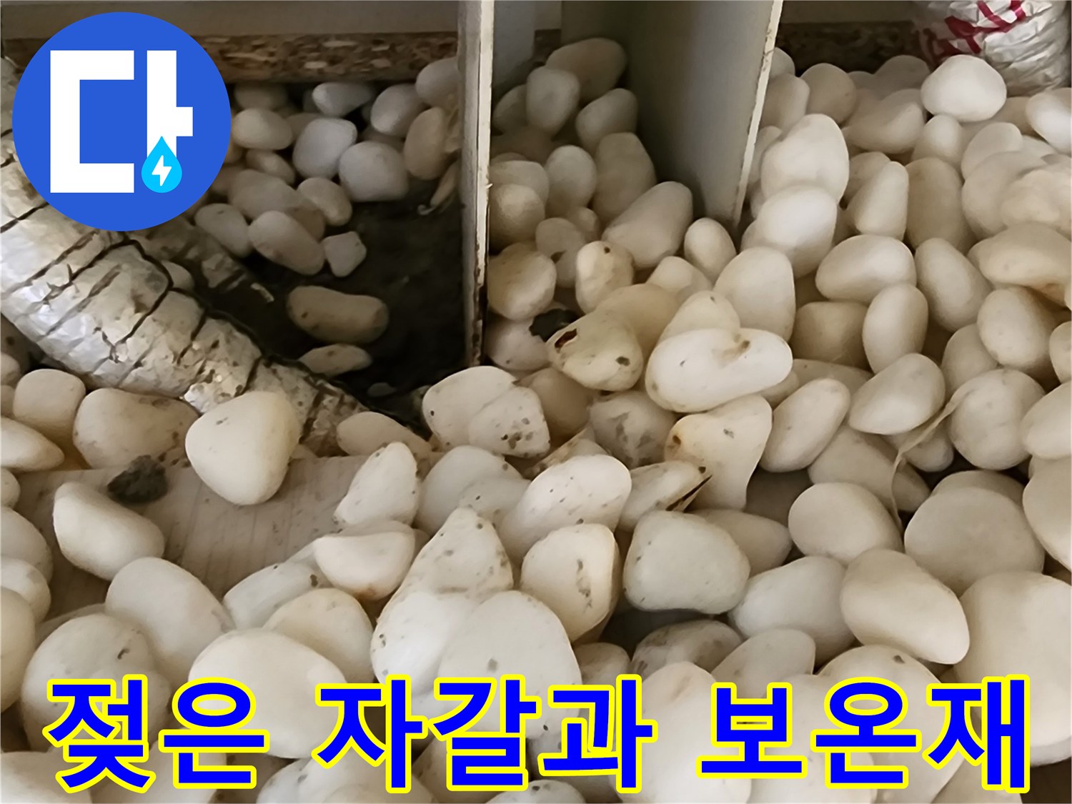 습기를 머금어 색이 변한 배관 주변의 하얀 자갈