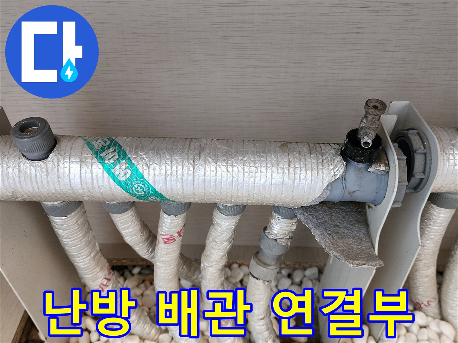 은박 보온재로 마감된 분배기 배관의 근접 사진