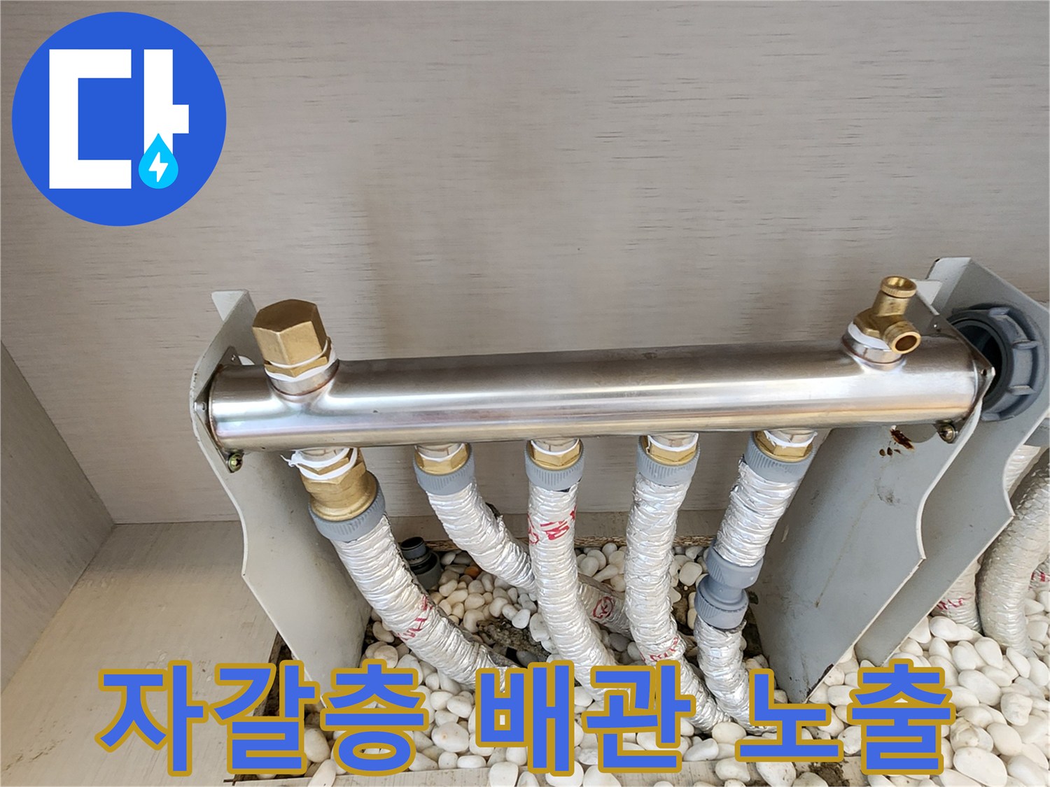 자갈로 채워진 바닥 공간에 설치된 난방 분배기 모습