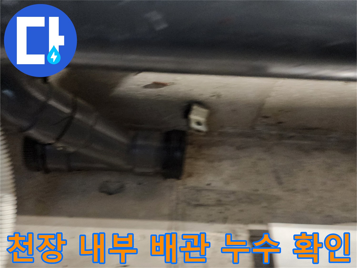 어두운 천장 안쪽의 검은색 하수관 연결 부위 근접 촬영