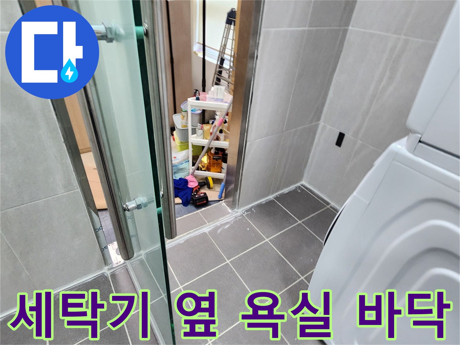 세탁기가 놓인 욕실 공간의 타일 마감 상태를 보여주는 사진입니다.
